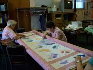 Myrna Atkinson and Carol Hubin quilting the butterfly pattern